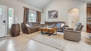 A spacious living room with a sectional sofa, a coffee table, and a fireplace.