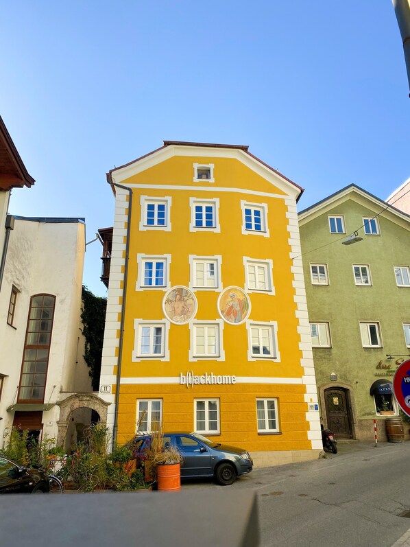 A yellow building with the name 'b(l)ackhome' on the facade, featuring multiple windows and a small balcony. - Blackhome Vintage Innsbruck (Innsbruck)