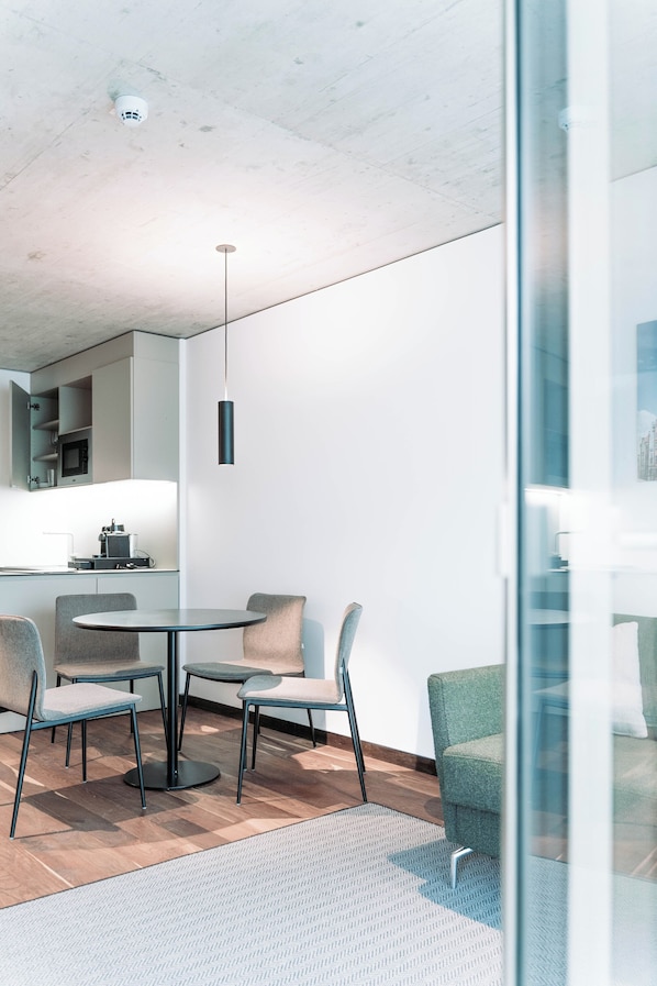 Una cocina moderna con una mesa redonda, sillas y una lámpara colgante.