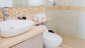 A modern bathroom with a large mirror, a sink, a toilet, and a shower area. - U-GO Palmetto Sunset Junto al Mar (Cartagena)