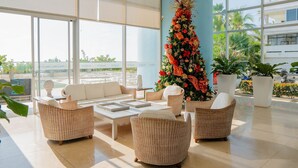 A spacious lobby with wicker furniture, a large Christmas tree, and a view of the outdoors. - U-GO Palmetto Sunset Junto al Mar (Cartagena)