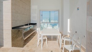 A modern kitchen with a granite countertop, a white dining table, and chairs. - U-GO Palmetto Sunset Junto al Mar (Cartagena)
