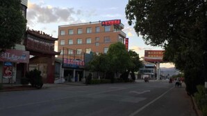 Un immeuble à plusieurs étages, avec une enseigne indiquant qu’il s’agit d’un hôtel. La façade est dotée de nombreuses fenêtres, et l’immeuble semble se trouver dans un quartier commercial, à proximité d’autres commerces.