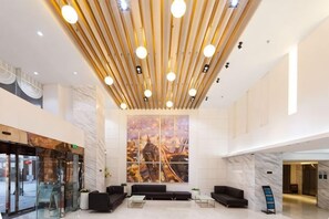 A modern lobby with a high ceiling, a large window with a cityscape view, and a reception desk. - Xinmi International Hotel (Shanghai Pudong International Airport Park Resort) (Shanghai)