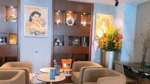 A modern hotel lobby with comfortable seating, decorative wall art, and a vase of flowers. - Xinmi International Hotel (Shanghai Pudong International Airport Park Resort) (Shanghai)