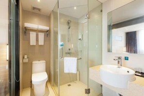 A modern bathroom with a glass-enclosed shower, a toilet, and a sink with a mirror above it. - Xinmi International Hotel (Shanghai Pudong International Airport Park Resort) (Shanghai)