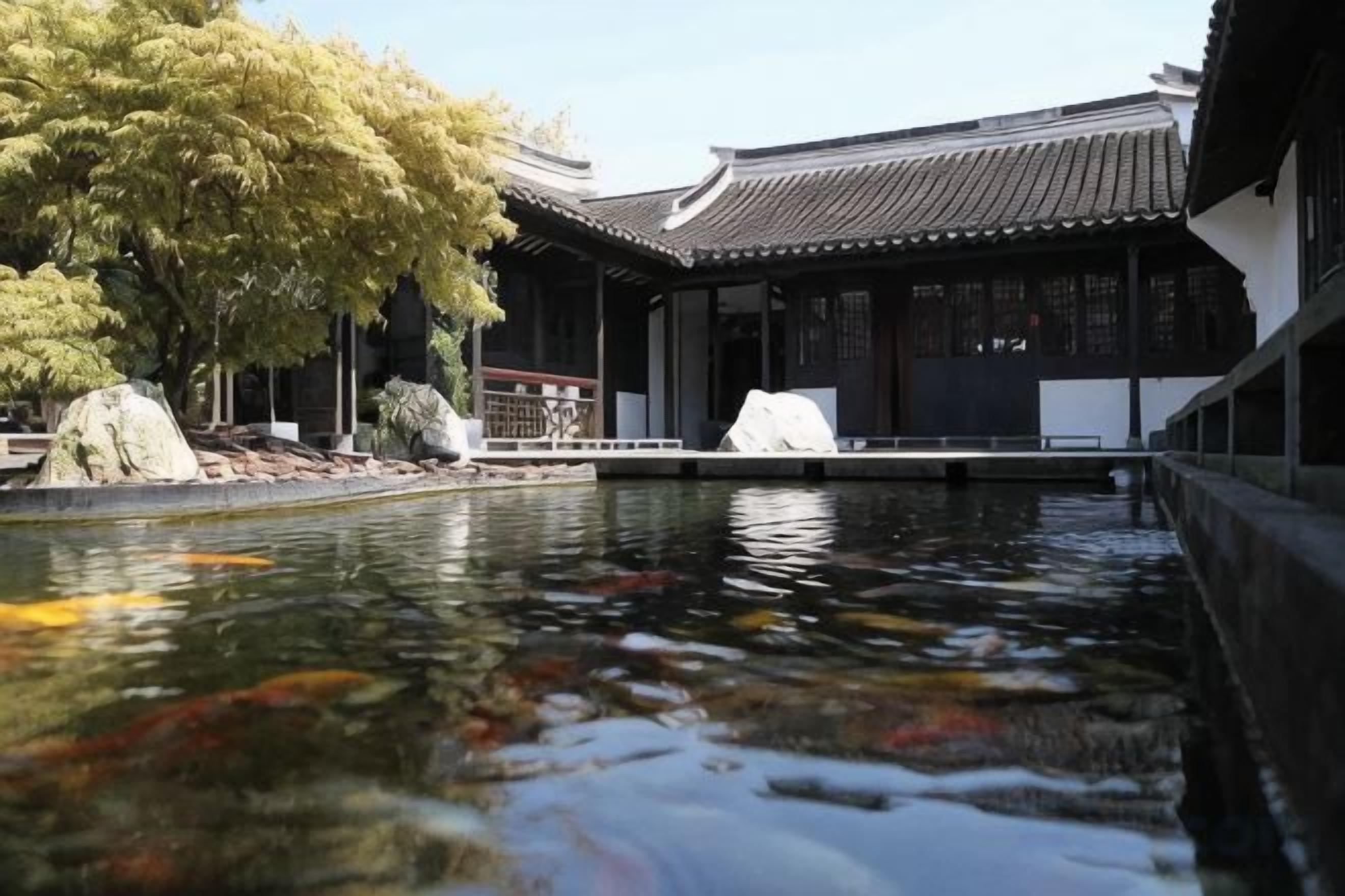 Ein traditionelles japanisches Gebäude mit einem Teich mit Koi-Karpfen davor.