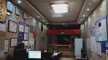 A reception area with a computer, chairs, and informational posters on the walls.