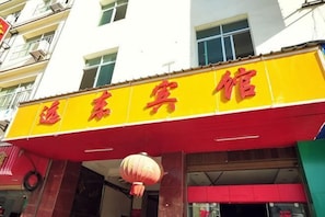A building with a yellow signboard with red Chinese characters. - Bohai Far East Hotel (Menghai)