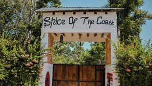 Un arco con el letrero "Spice Of The Coast" que da paso a un portón de madera.