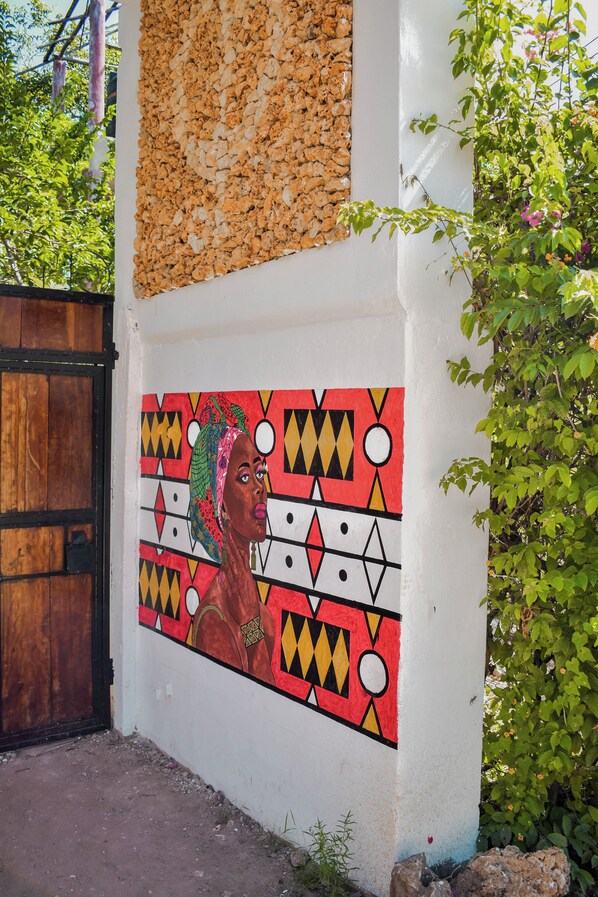 Una pared con un mural colorido y una puerta de madera.
