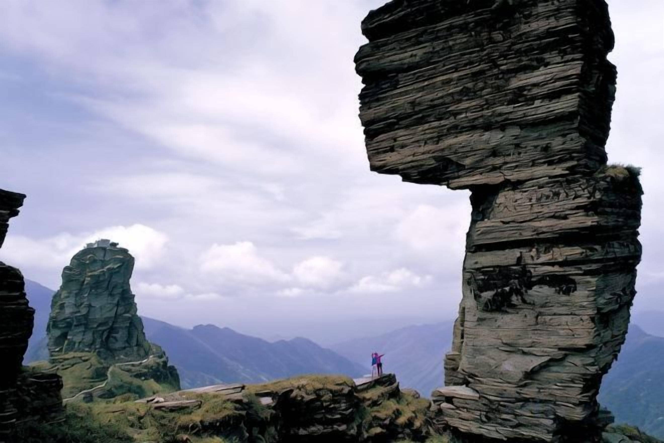 A natural rock formation with a person standing on a ledge.