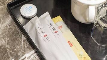 Un plateau avec des sachets de thé et une tasse à thé, posé sur un comptoir en marbre.