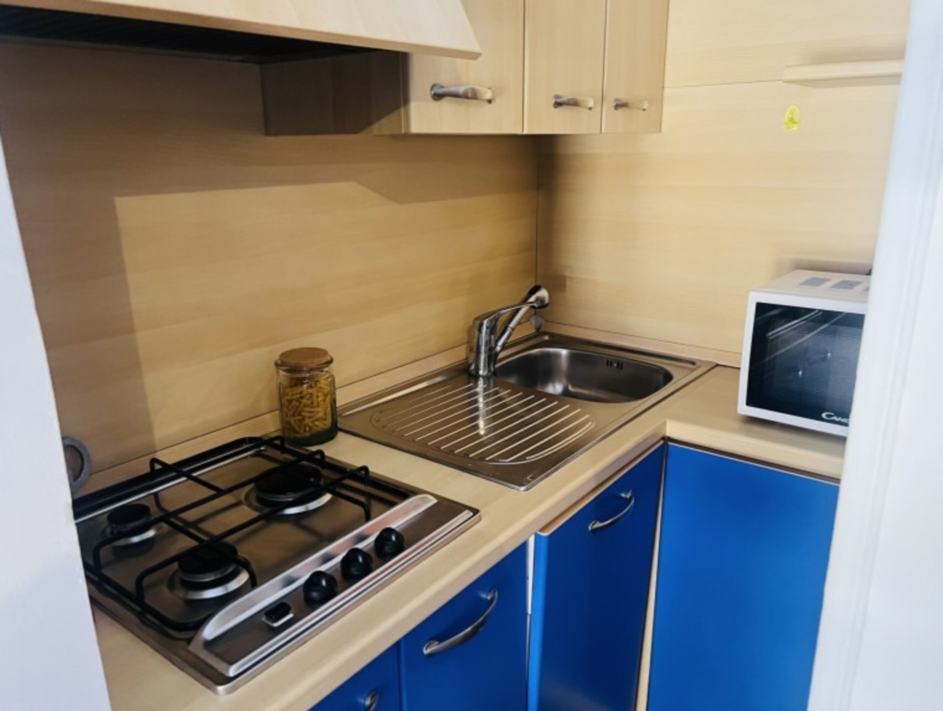 A kitchen with a gas stove, a sink, and a toaster.