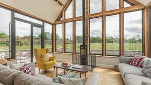 A spacious room with large windows, a fireplace, and comfortable seating. - 4 bedroom accommodation in Middlezoy, near Bridgwater (Middlezoy, near Bridgwater)