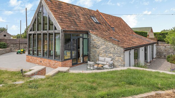 A modern house with a glass extension, stone walls, and a tiled roof. - 4 bedroom accommodation in Middlezoy, near Bridgwater (Middlezoy, near Bridgwater)