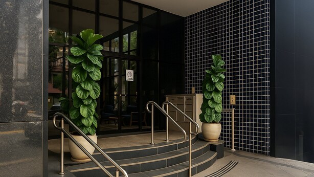 A set of outdoor stairs leading to a building entrance with metal handrails, potted plants, and a tiled wall. - Elegance Suítes Jardins (São Paulo)
