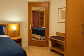 A hotel room with a bed, bedside table, lamp, and a wardrobe. - Elegance Suítes Jardins (São Paulo)