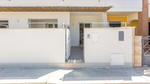 A modern building with a white facade, a covered entrance, and a visible door. - Residence Albeach - Bilo 3 (Porto Cesareo)