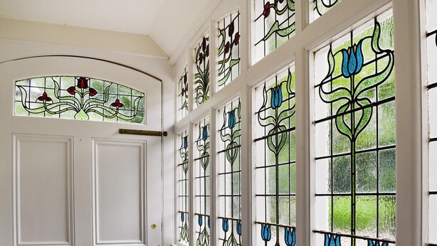 A room with a white door and multiple stained glass windows with floral designs. - 6 bedroom accommodation in Okehampton (Okehampton)