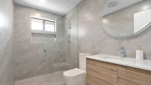 A modern bathroom with a glass-enclosed shower, a toilet, and a vanity with a mirror. - Fresh Seas - Mornington (Mornington)