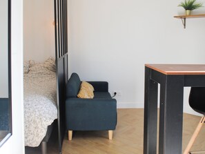 Cozy living space with a sofa, side table, and potted plant.
