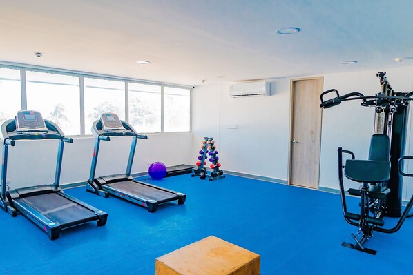 A gym with treadmills, a stationary bike, a medicine ball, and a squat rack. - U-GO Edificio Ocean Drive en Crespo (Cartagena)