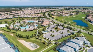 An aerial view of a residential community with multiple houses, a central swimming pool, and a golf course. - Last Minute Disney! Townhouse with Private Pool. Book Now! #CG3435 (Orlando)