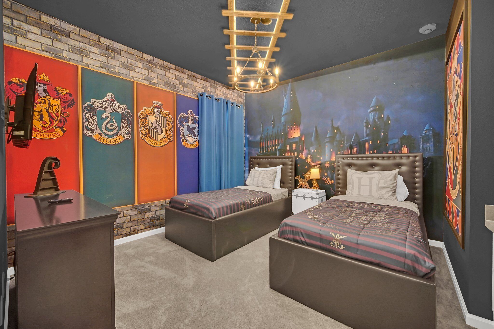 Een slaapkamer met twee bedden, een bakstenen muur en een muurschildering gebaseerd op Harry Potter.