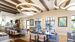 A spacious dining area with multiple tables and chairs, large windows with views, and a modern ceiling design. - Disney! Private Pool, Hot Tub, Game Room & Themed Bedrooms. Book Now! #Solara567 (Orlando)