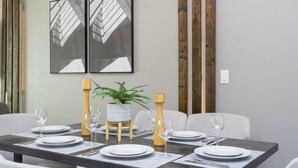 A dining table set with plates, glasses, and cutlery, flanked by chairs and a potted plant. - Disney! Private Pool, Hot Tub & Themed Bedrooms. Book Now! #VDR14 (Orlando)