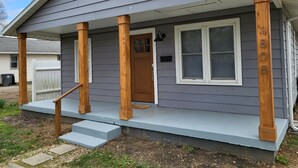 A single-story house with a porch, a front door, and a mailbox.