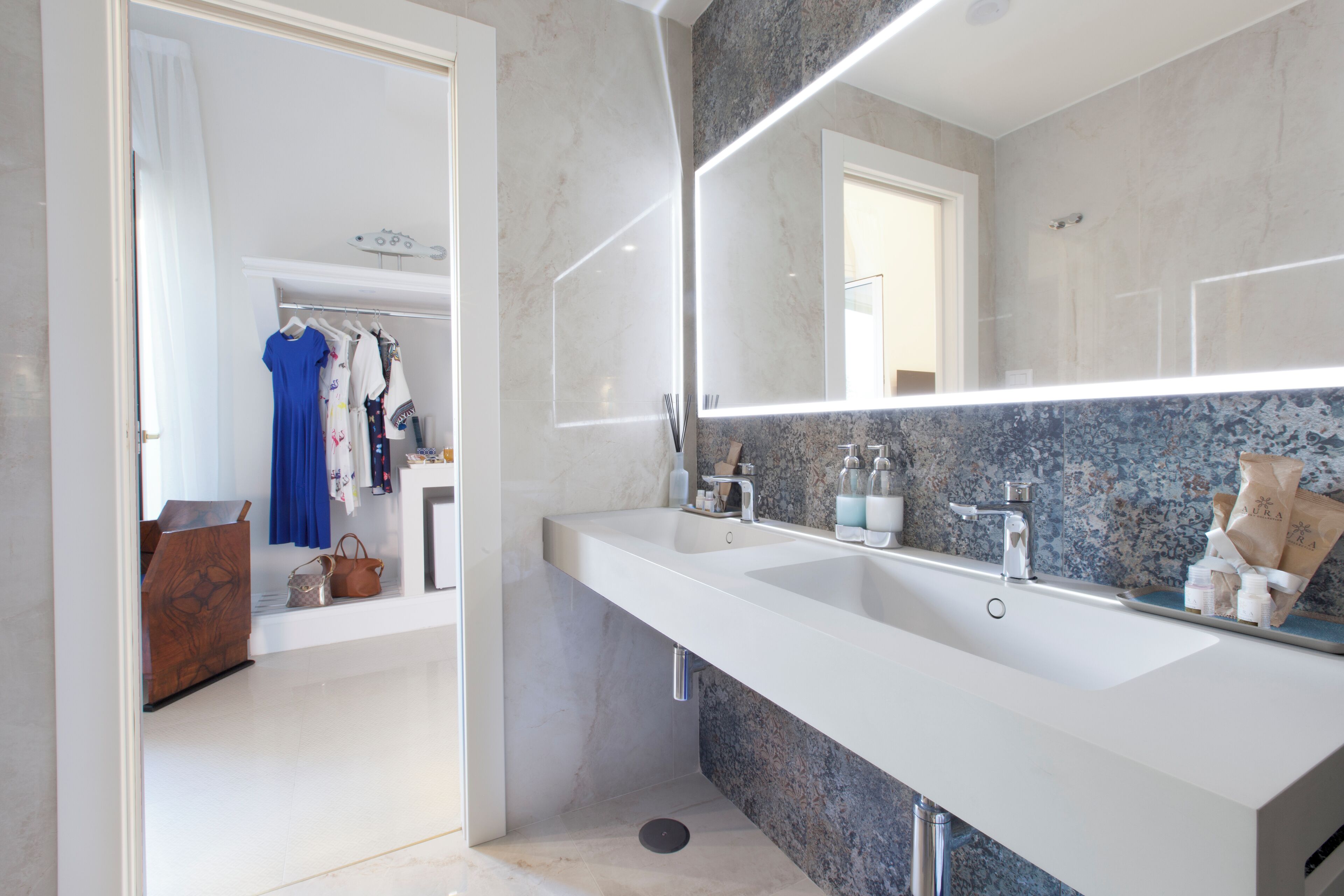 A modern bathroom with a large mirror, two sinks, and a vanity.