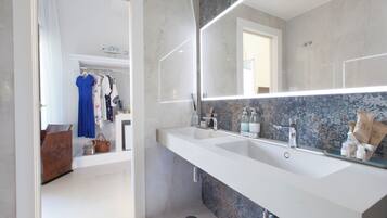 A modern bathroom with a large mirror, two sinks, and a vanity.