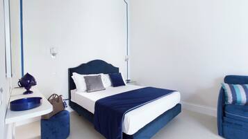 A modern bedroom with a bed, bedside table, and a chair.