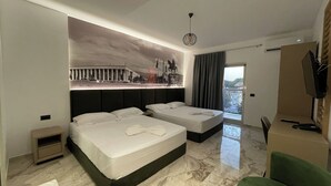 A hotel room with two beds, a mural on the wall, a balcony with a view, and a television. - Hotel Ruko Boutique (Golem)