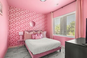 Quarto decorado em tons de rosa, com cama, mesa de cabeceira e janela com persianas.