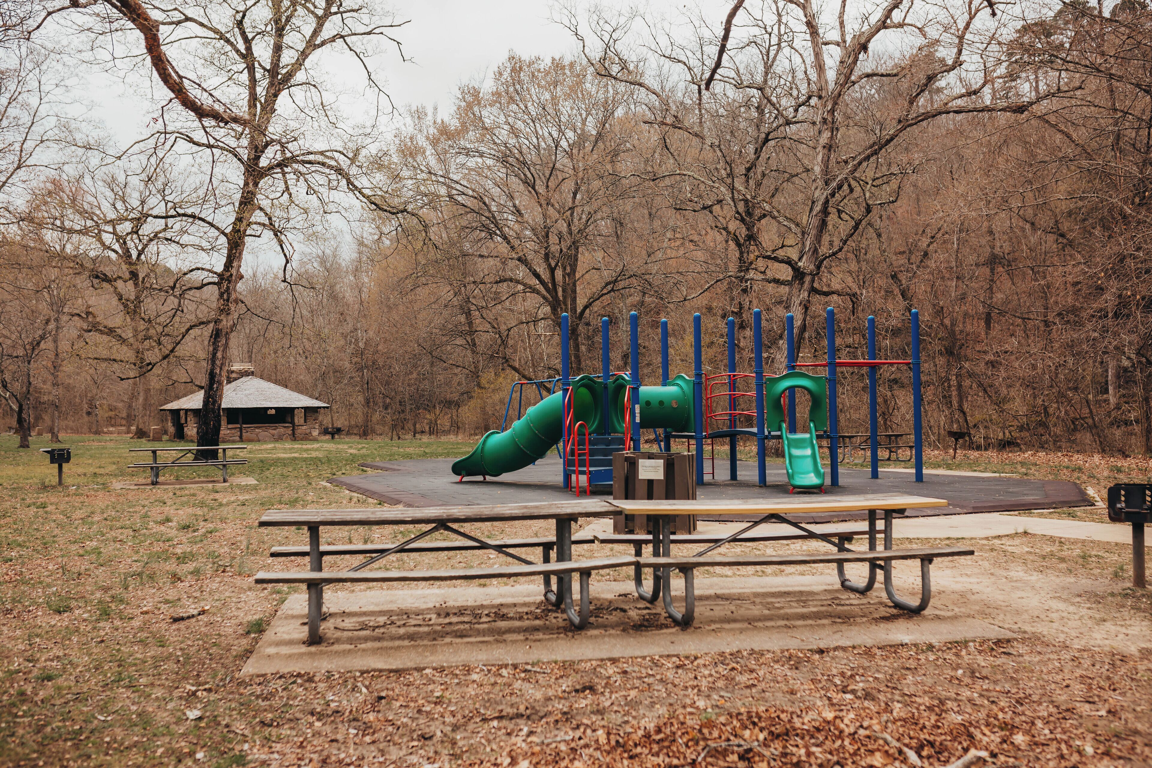 A playground with a slide, climbing structure, and a picnic table area.