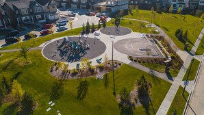 Luchtbeeld van een woonwijk met huizen, een speeltuin en een basketbalveld.