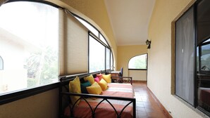 Un dormitorio con cama, ventanas amplias y vista al exterior.