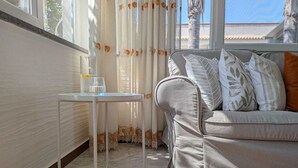 A living room with a sofa, a small table, and a glass of water. - Near Palermo Airport (PMO): Private Villa with Garden, Ideal for Families (Carini)