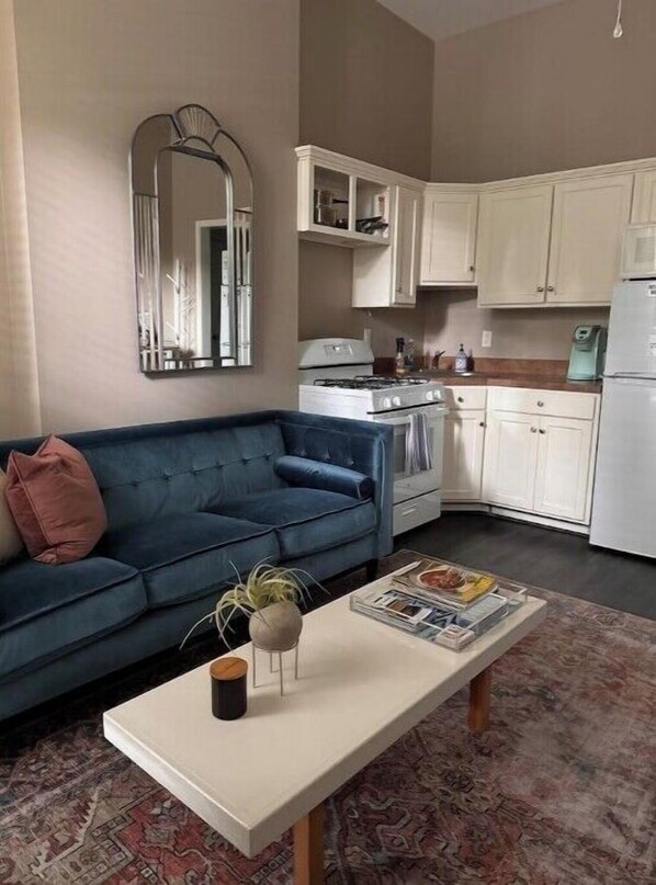Cozy living space with a sofa, coffee table, and kitchenette.