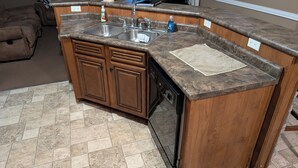 Eine Küche mit Granitabdeckung, doppelter Spüle und Holzschränken.