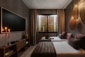 A hotel room with a large flat-screen TV, two beds, a wooden console table, and a window with wooden shutters. - Casa Kutzi Kutzi Paradise Villa Beach Club Access (Tulum)