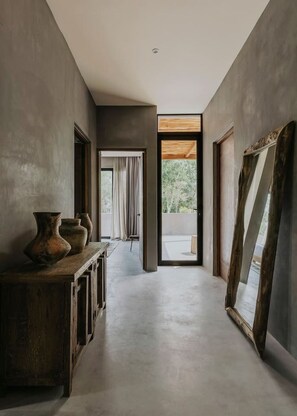 Stylish hallway with console table, mirrors, and a glass door leading to a balcony with a view.