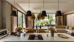 A modern kitchen with a central island, pendant lights, and a view of the outdoors. - Casa Kutzi Kutzi Paradise Villa Beach Club Access (Tulum)