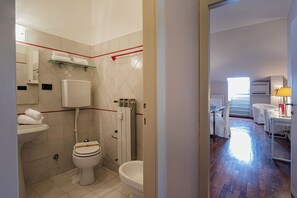 A modern bathroom with a toilet, bidet, and a glass shelf with towels. - Garibaldi Attic by Wonderful Italy (Genoa)