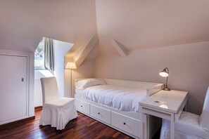 A small, neatly arranged bedroom with a single bed, a desk, and a chair. - Garibaldi Attic by Wonderful Italy (Genoa)