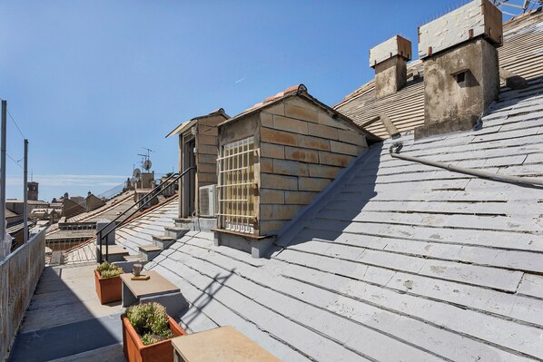A rooftop terrace with a small wooden structure, a metal railing, and potted plants. - Garibaldi Attic by Wonderful Italy (Genoa)