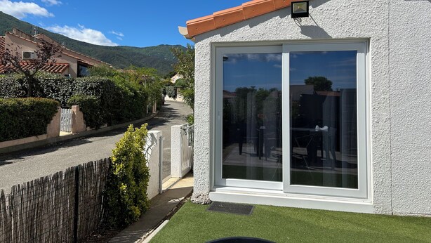 A house with a large window, a white exterior, and a red roof. - T2 vacation home in Sorède, near Argeles, with swimming pool and private parking (Sorède)